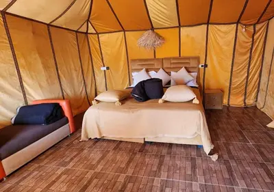 a bedroom with a bed in a tent at Merzouga nights camp& excursions in Merzouga