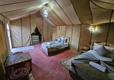 a room with a tent with two beds in it at Merzouga nights camp& excursions in Merzouga