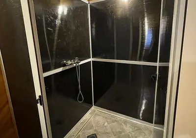 a shower with a glass door in a bathroom at Merzouga nights camp& excursions in Merzouga