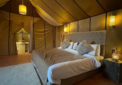a bedroom with a bed in a tent at Merzouga nights camp& excursions in Merzouga