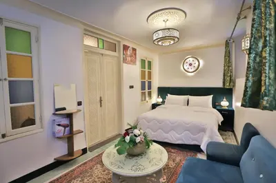 a hotel room with a bed and a couch at Dar Chaima Apartment in Fès
