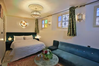 a living room with a bed and a couch at Dar Chaima Apartment in Fès