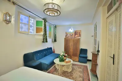 a living room with a blue couch and a table at Dar Chaima Apartment in Fès