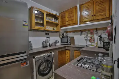 a kitchen with wooden cabinets and a washing machine at Dar Chaima Apartment in Fès