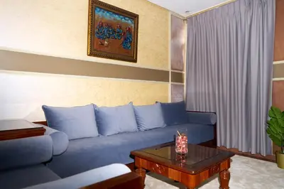 a living room with a blue couch and a table at Hotel Bab Mansour in Meknès