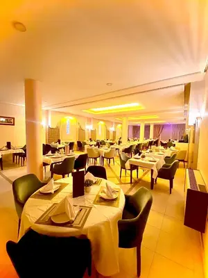 a restaurant with white tables and chairs and tablesearcher at Hotel Bab Mansour in Meknès