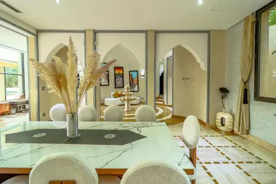 a dining room with a glass table and chairs at Villa d'exception spa, sport & piscine in Najem