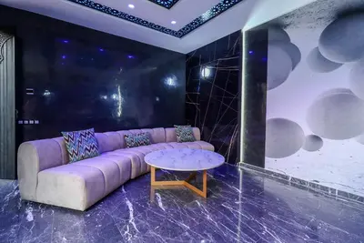 a living room with a purple couch and a table at Villa d'exception spa, sport & piscine in Najem