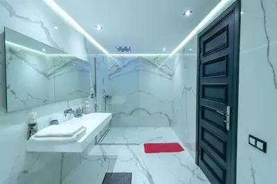 a white bathroom with a sink and a mirror at Villa d'exception spa, sport & piscine in Najem