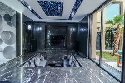 a living room with black walls and a ceiling at Villa d'exception spa, sport & piscine in Najem