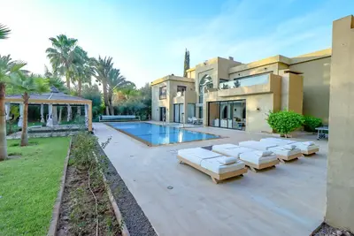 a house with a swimming pool and some lounge chairs at Villa d'exception spa, sport & piscine in Najem