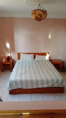 a bedroom with a bed with a striped comforter at John's Place in Had Abdallah Rhiat
