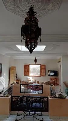 a chandelier hanging from the ceiling in a living room at John's Place in Had Abdallah Rhiat