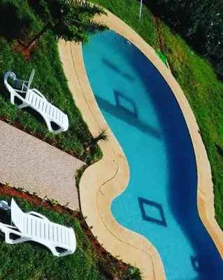 an overhead view of a swimming pool with two white loungers next to at la ferme zine in Ain Cheggag