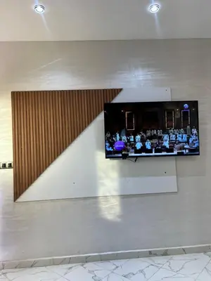 a tv on a wall with a group of people at la ferme zine in Ain Cheggag