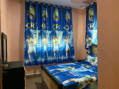 a bedroom with a bed with a blue curtain at la ferme zine in Ain Cheggag
