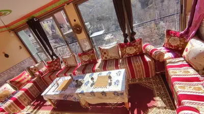 a group of chairs in a room with windows at GITE DETAPE DAR AGSWAL DOUAR WANSKRA OUED IMNANE ASNI MARRAKECh in Tacheddirt