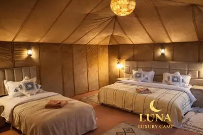 a bedroom with two beds in a tent at Luna Luxury Camp Merzouga in Merzouga