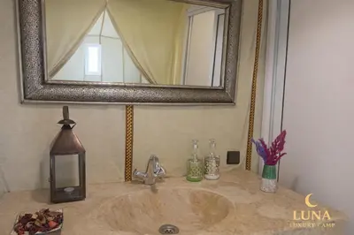 a bathroom sink with a mirror on top of it at Luna Luxury Camp Merzouga in Merzouga