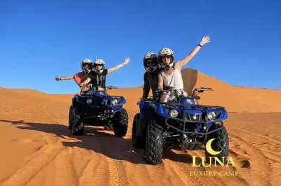 a group of people riding on atvs in the desert at Luna Luxury Camp Merzouga in Merzouga