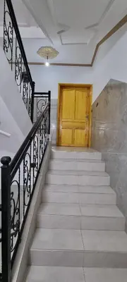 a staircase with a wooden door and a yellow door at Appartement neuf centre ville de Tinghir in Tinerhir