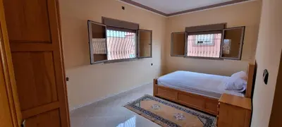 a small bedroom with a bed and two windows at Appartement neuf centre ville de Tinghir in Tinerhir