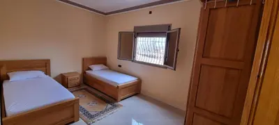 a small bedroom with two beds and a window at Appartement neuf centre ville de Tinghir in Tinerhir