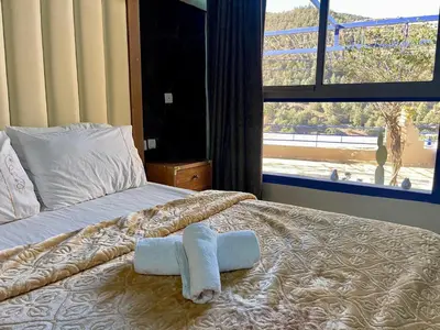 a bed with a towel on it with a window at Kasbah Tifirte Grand Vallet in Ourika