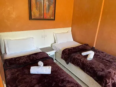two beds in a hotel room with towels at Kasbah Tifirte Grand Vallet in Ourika