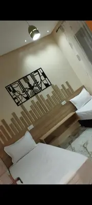 a bedroom with two beds and a sign on the wall at Appartement meublé in Meknès