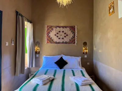 a bedroom with a bed with towels on it at Heritage House Skoura in Skoura