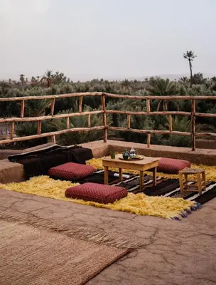 a table and cushioned chairs and a table and a table and a table at Heritage House Skoura in Skoura