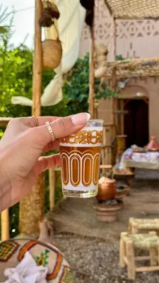 a person holding up a cup of coffee at Heritage House Skoura in Skoura
