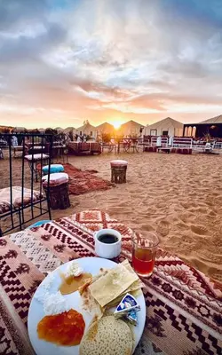 a plate of food on a table in the desert at Safari trips Morocco luxury camp in Merzouga