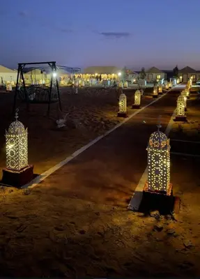 a long road with lights on it at night at Safari trips Morocco luxury camp in Merzouga
