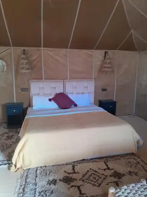 a bedroom with a large bed in a tent at Safari trips Morocco luxury camp in Merzouga