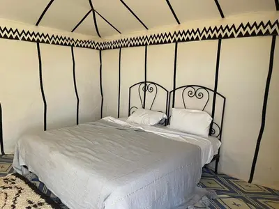 a bedroom with a bed with two pillows on it at Camp Sahara Feeling in El Gouera