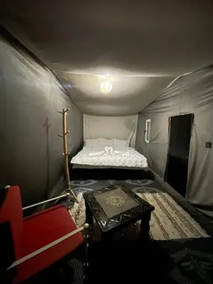 a small room with a bed in a tent at Camp Sahara Feeling in El Gouera