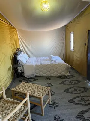 a bedroom with a bed in a tent at Camp Sahara Feeling in El Gouera