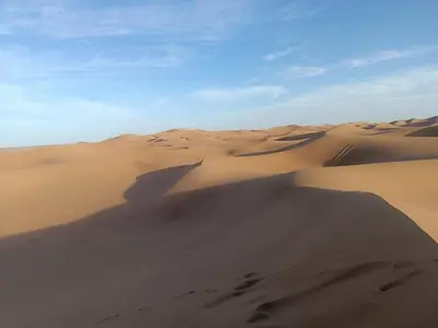 a group of sand dunes in the desert at Camp Sahara Feeling in El Gouera