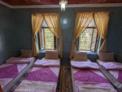 a bedroom with four beds in a room with windows at Gite D'etape Ait Ali Nito Assounfou in Megdaz