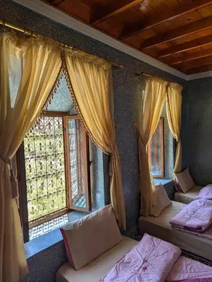 a room with three beds and windows with curtains at Gite D'etape Ait Ali Nito Assounfou in Megdaz