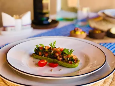 a plate with a vegetable dish on a table at Pueblo Touareg - Private Tents in Merzouga