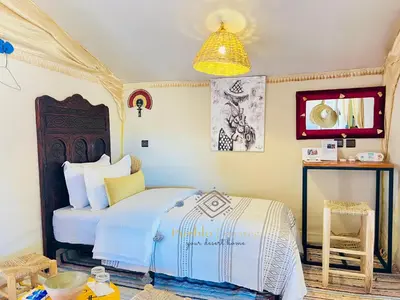 a bedroom with a bed and a chandelier at Pueblo Touareg - Private Tents in Merzouga