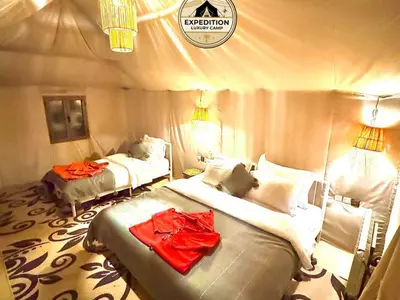 a bedroom with two beds in a tent at Expedition Luxury camp in Merzouga