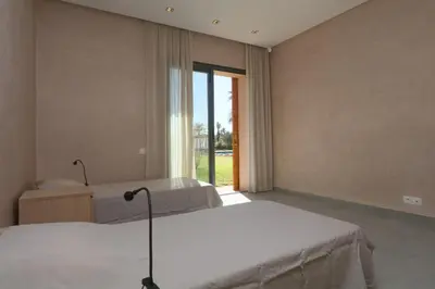 a bedroom with two beds and a large window at Magnifique Villa dans domaine prive in Douar Soukkane