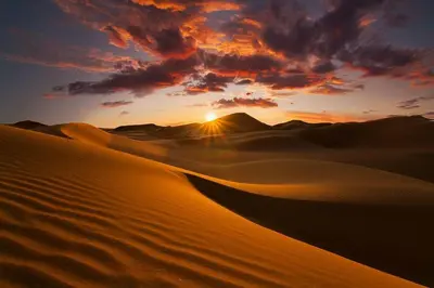 a sunset over the sand dunes in the desert at Erg chagaga in Mhamid