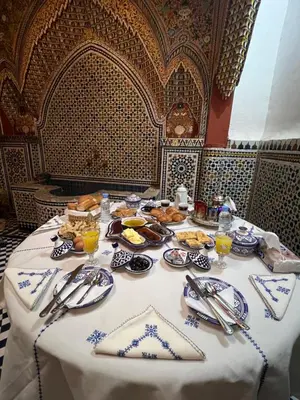 a table with a white table cloth with food on it at Dar Moulin in Fès