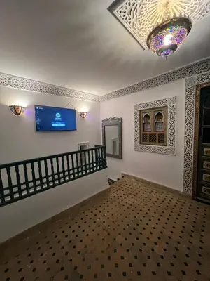 a living room with a tv on the wall at Dar Moulin in Fès