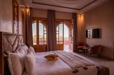a bedroom with a large bed and a balcony at Palais Menzah & SPA in Marrakech